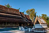 Wat Xieng Thong temple in Luang Prabang, Laos. The pointed arch brick and stucco shrine with inside is a standing Buddha statue. 